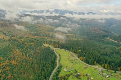 Photo of Aerial view of beautiful forest, road and mountain village on autumn day