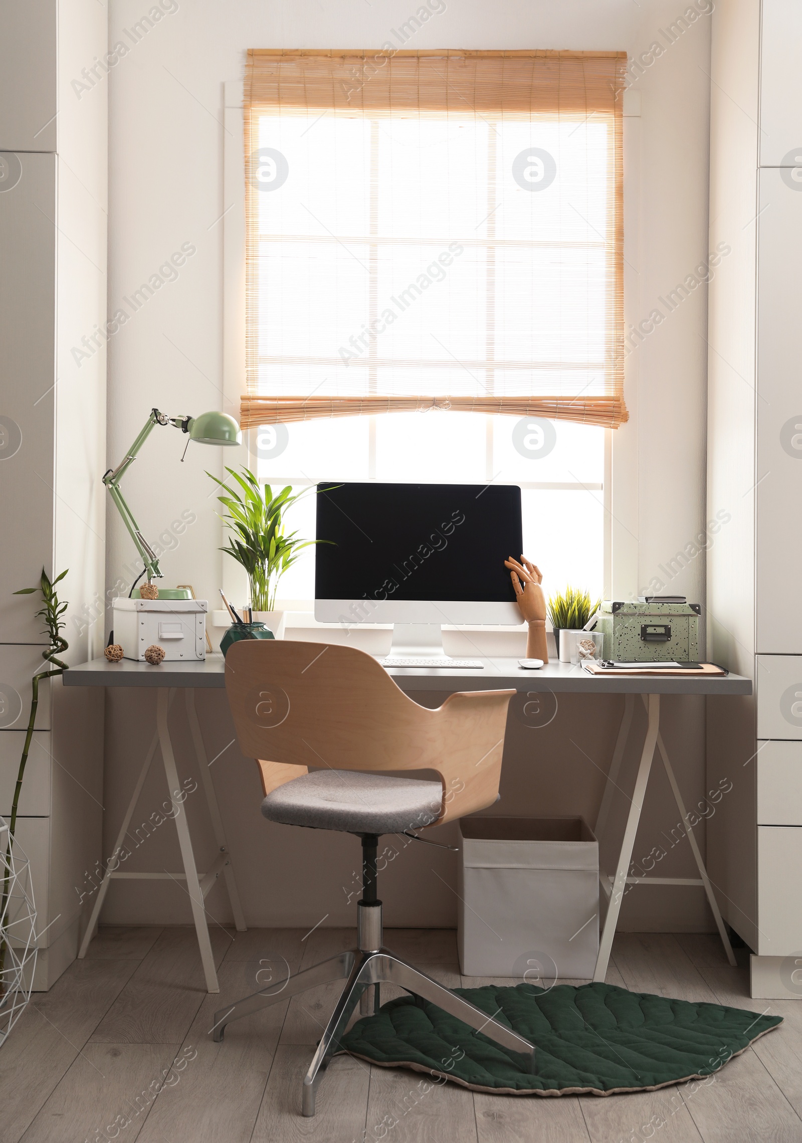 Photo of Light work place with computer near window at home. Interior design