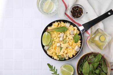 Photo of Delicious scrambled eggs with tofu and ingredients on white table, flat lay. Space for text
