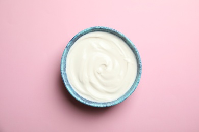 Photo of Bowl with creamy yogurt on color background, top view