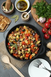 Photo of Delicious ratatouille and ingredients on grey table, flat lay