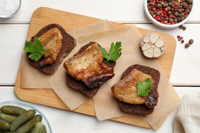 Rye bread with tasty fried cracklings on white wooden table, flat lay. Cooked pork lard