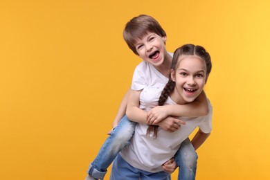 Photo of Happy brother and sister on orange background