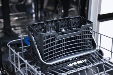 Open clean empty dishwasher indoors, closeup. Home appliance