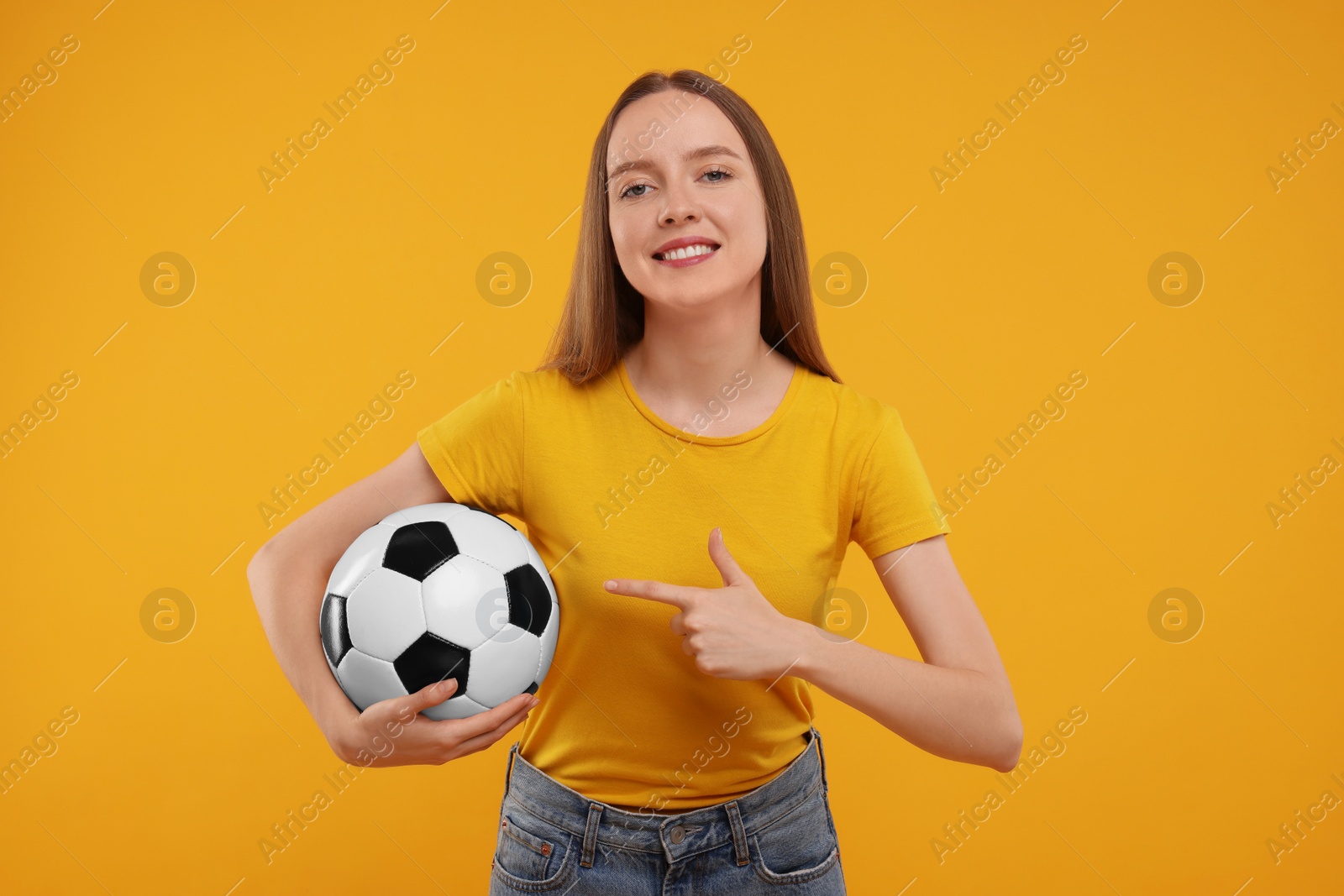 Photo of Happy sports fan with ball on yellow background