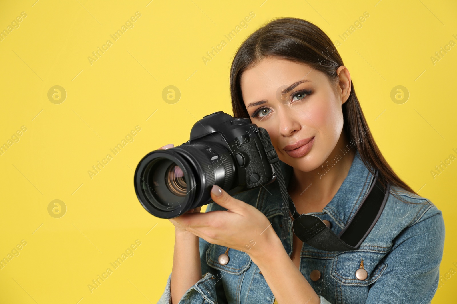 Photo of Professional photographer working on yellow background in studio