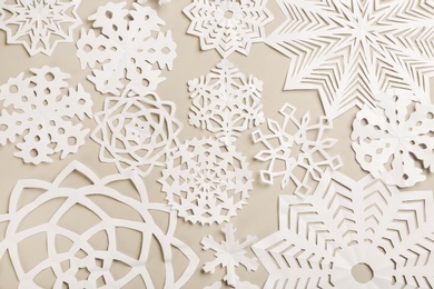 Many paper snowflakes on light grey background, flat lay