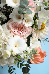 Photo of Bouquet of beautiful flowers on light blue background, closeup