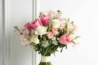 Photo of Beautiful bouquet of fresh flowers near white wall