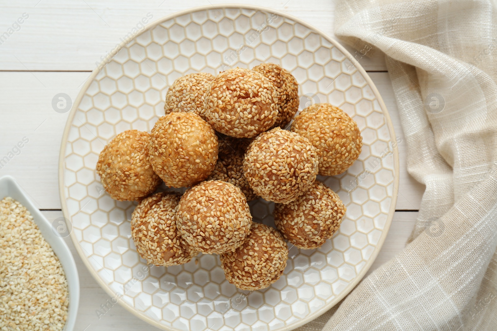 Photo of Delicious sesame balls on white wooden table, flat lay