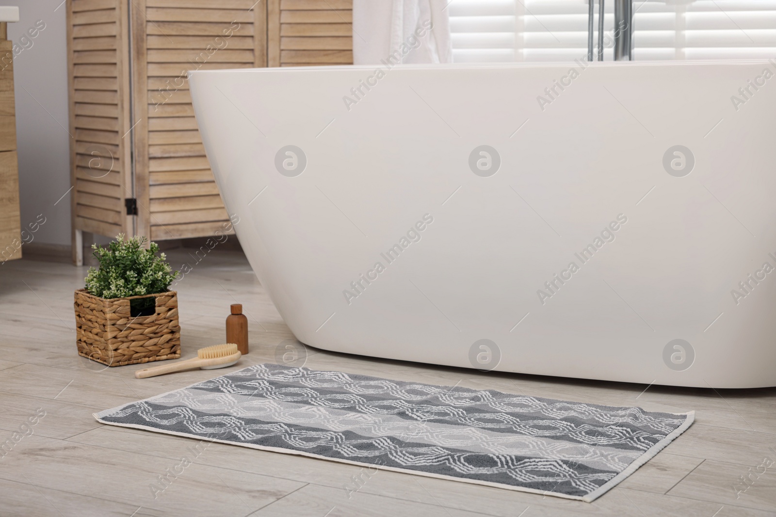 Photo of Soft bath mat with pattern on floor in bathroom