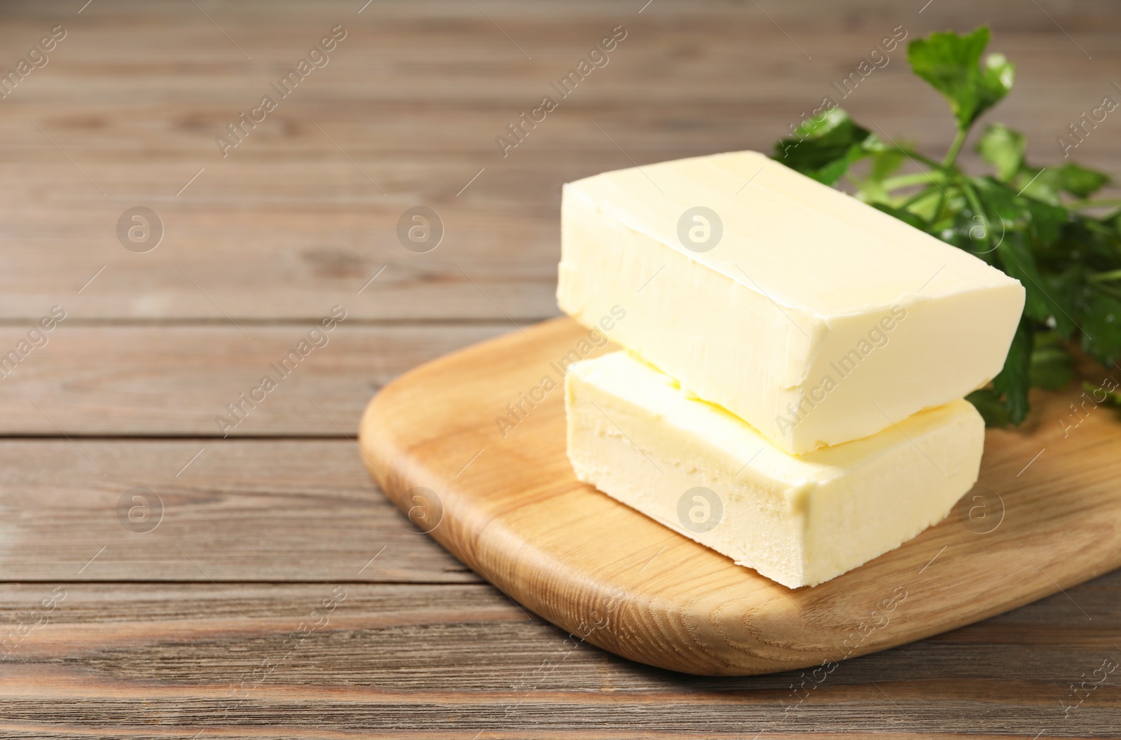 Photo of Tasty butter and parsley on wooden table. Space for text