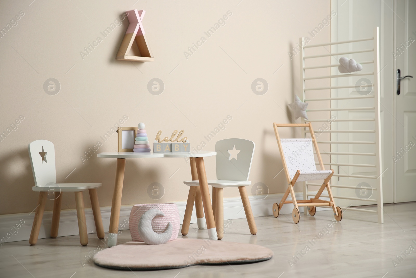 Photo of Baby room interior with stylish table, chairs and toys