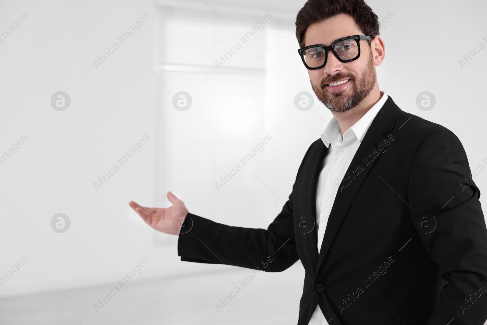Photo of Happy real estate agent showing new house. Space for text