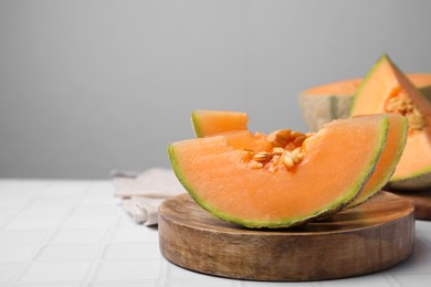 Tasty colorful ripe melons on white table, space for text