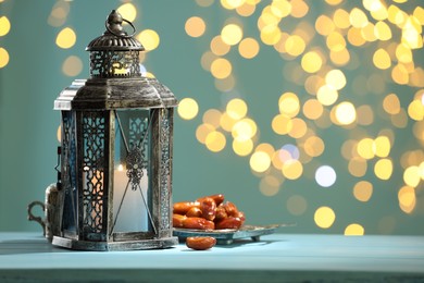 Photo of Traditional Arabic lantern and dates on table against blurred lights. Space for text