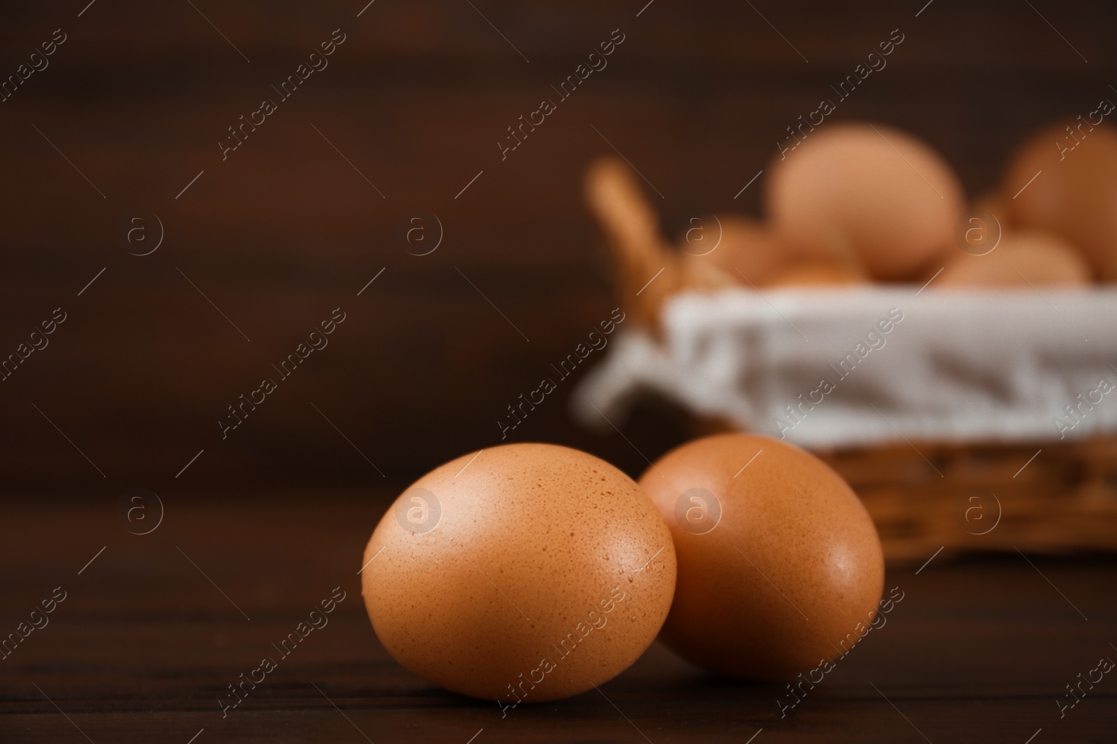 Photo of Raw chicken eggs on wooden table, closeup. Space for text