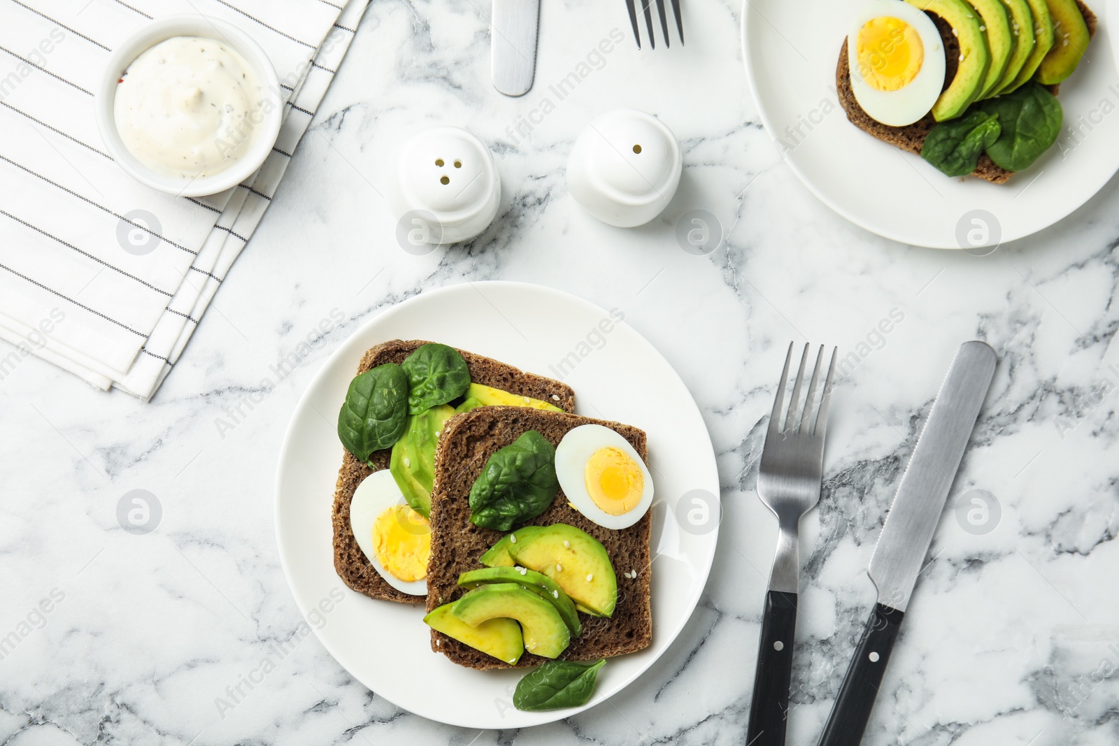 Photo of Flat lay composition with avocado toasts on white marble table