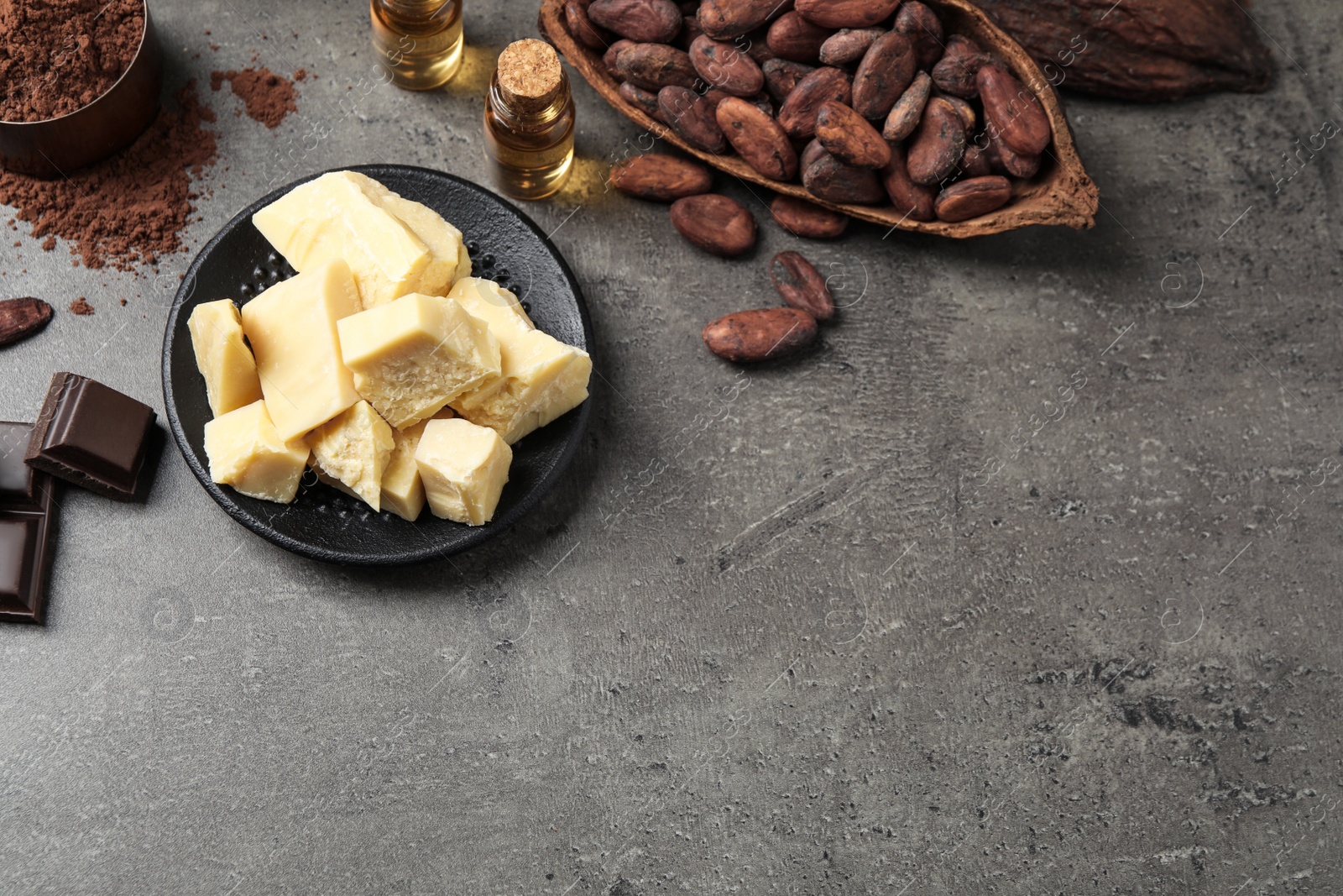 Photo of Flat lay composition with organic cocoa butter on grey table. Space for text