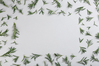 Photo of Frame made of fresh rosemary on light background, flat lay. Space for text