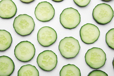 Photo of Fresh slices of cucumbers on white background, top view