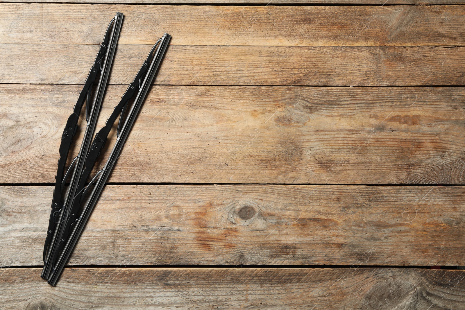 Photo of Car windshield wipers on wooden background, flat lay. Space for text