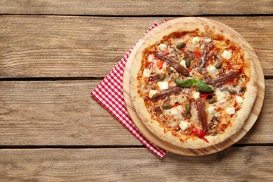 Tasty pizza with anchovies, basil and olives on wooden table, top view. Space for text