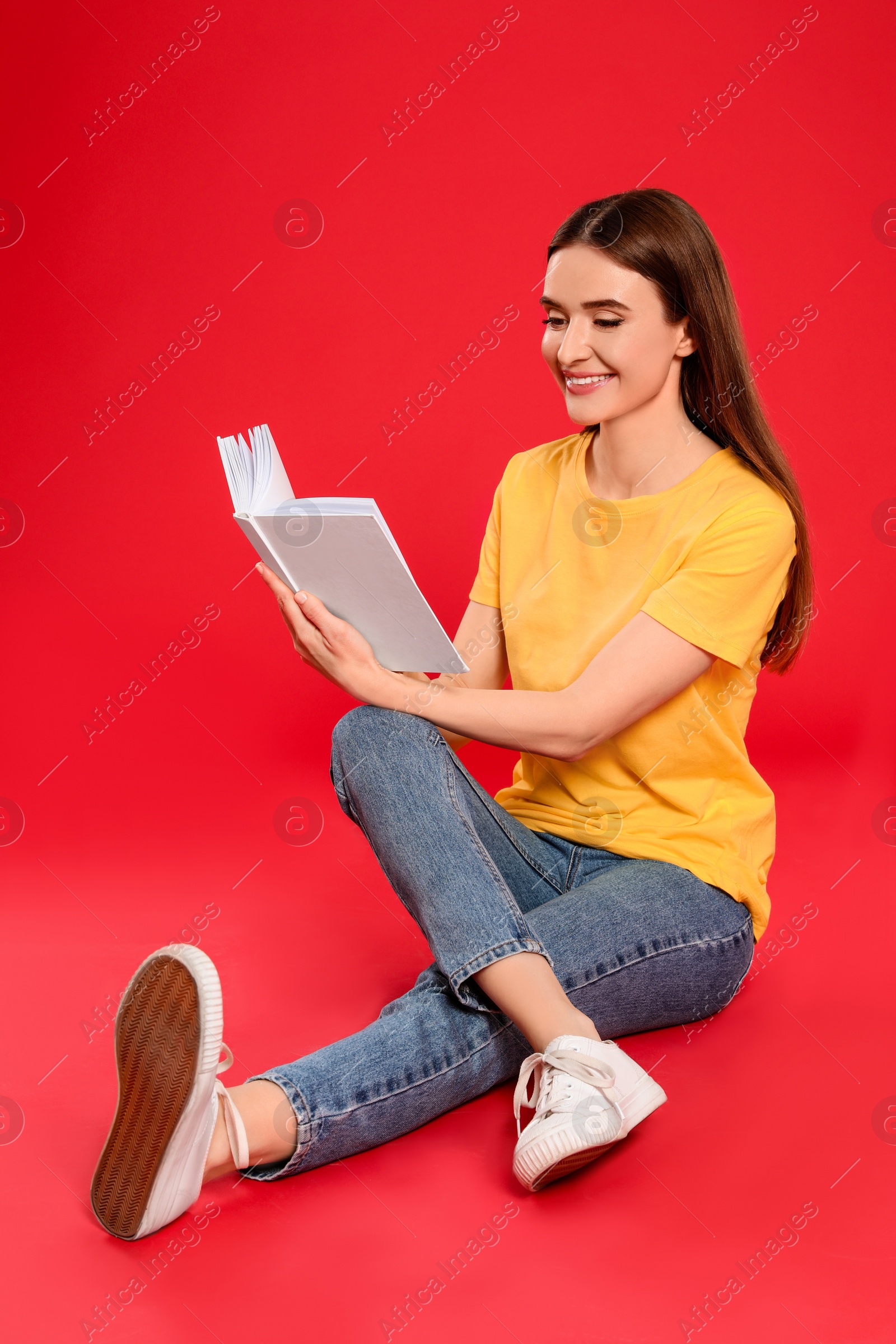 Photo of Young woman reading book on color background, space for text