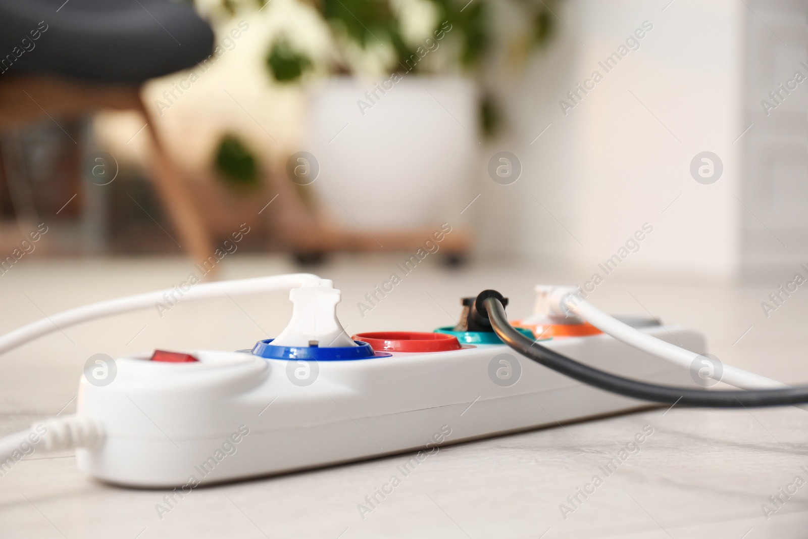 Photo of Extension cord on floor indoors, space for text. Electrician's professional equipment