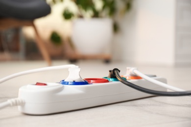 Extension cord on floor indoors, space for text. Electrician's professional equipment