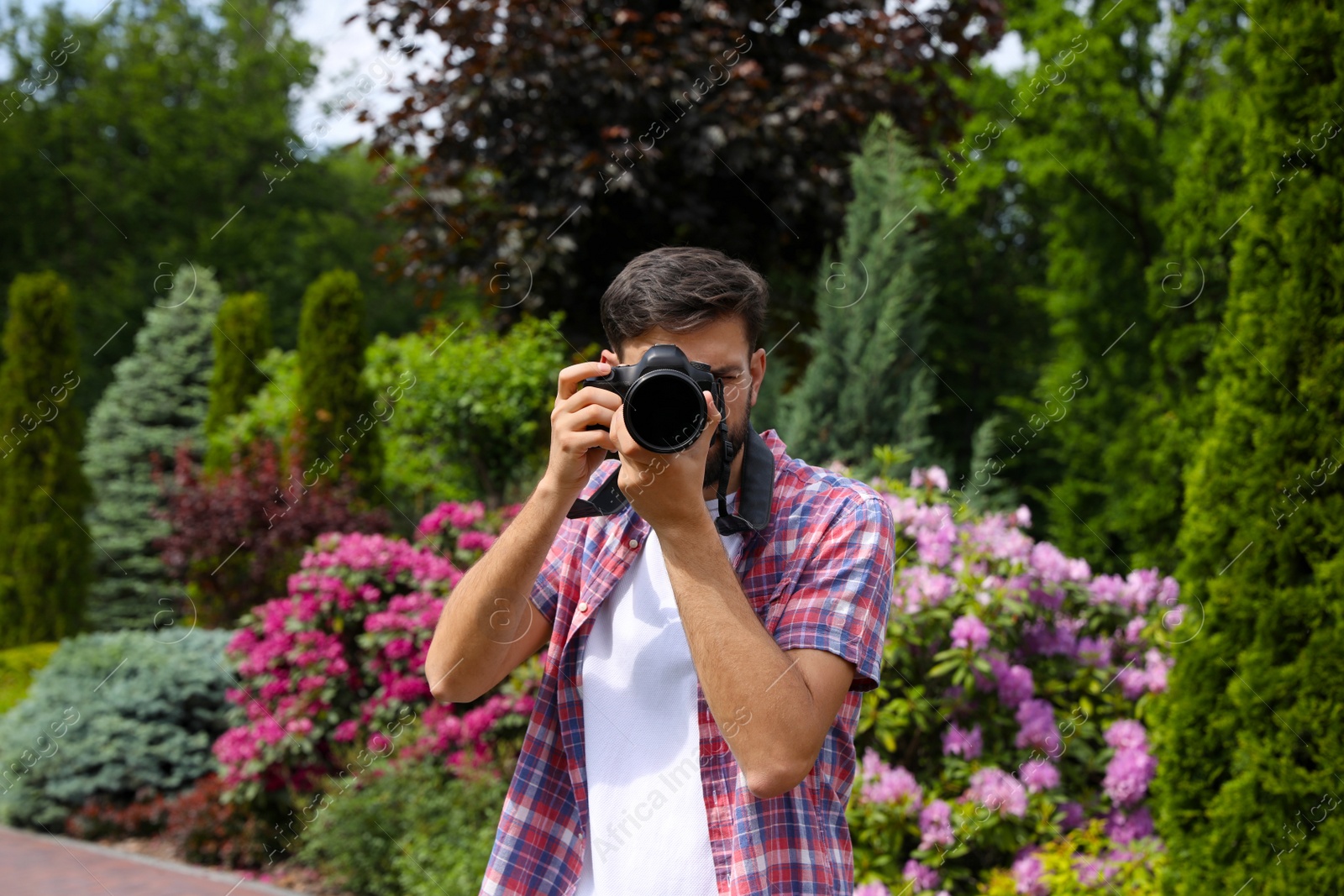 Photo of Photographer taking photo with professional camera in park