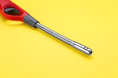 Photo of One gas lighter on yellow background, closeup