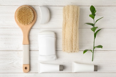 Photo of Flat lay composition with natural deodorant and bath accessories on white wooden table