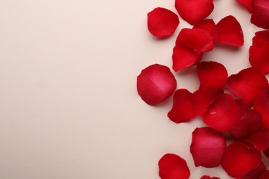 Photo of Beautiful red rose flower petals on beige background, flat lay. Space for text