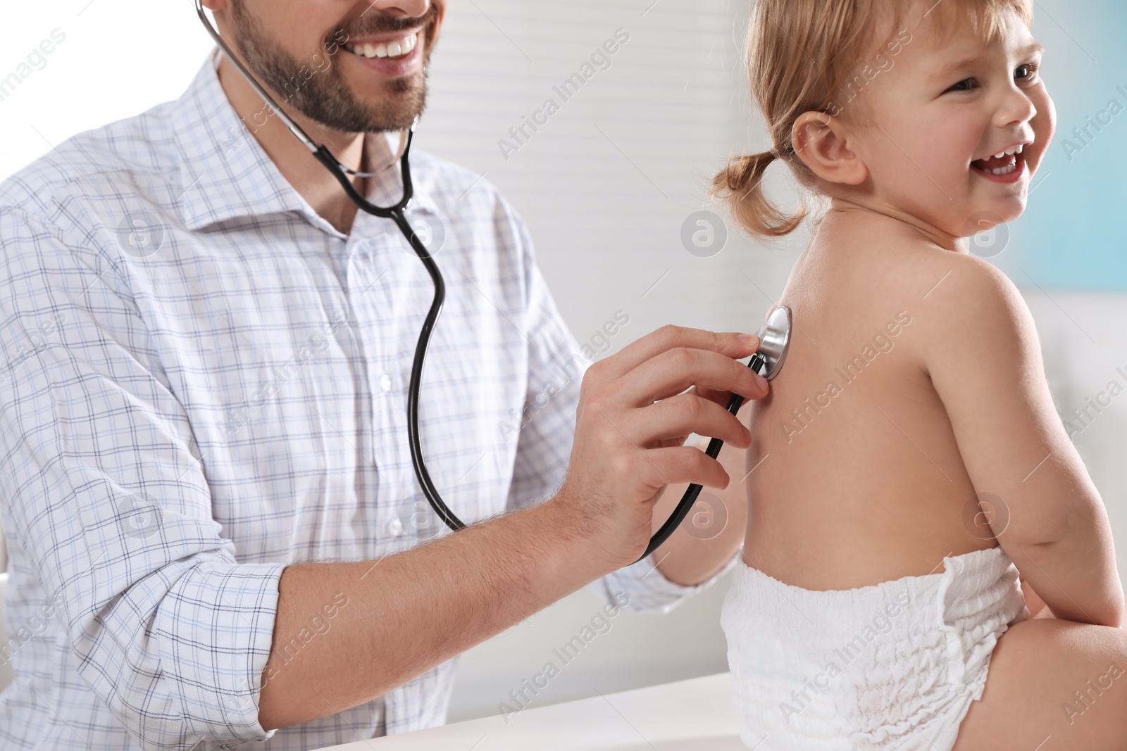 Photo of Pediatrician examining baby with stethoscope in clinic