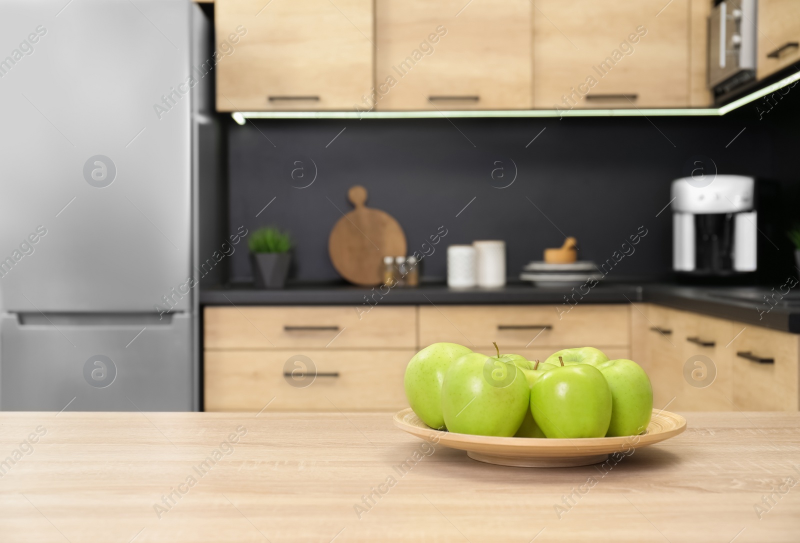 Photo of Fresh green apples on wooden table in kitchen. Space for text