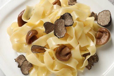 Tasty tagliatelle with truffle on white plate, closeup