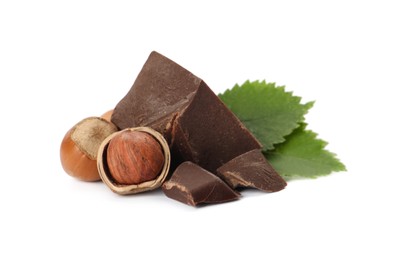 Delicious chocolate chunks with hazelnuts and green leaves on white background