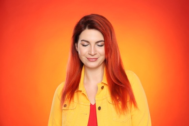 Photo of Young woman with bright dyed hair on color background