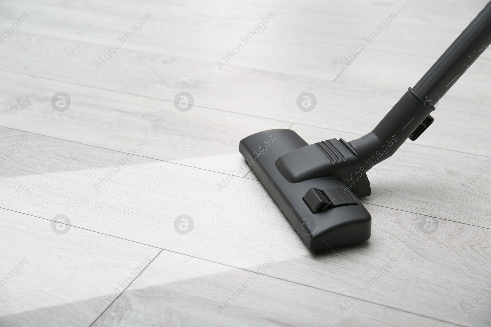 Image of Vacuuming dirty white wooden floor. Clean area after using device, closeup