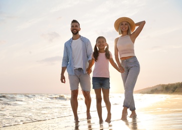 Happy family on sandy beach near sea