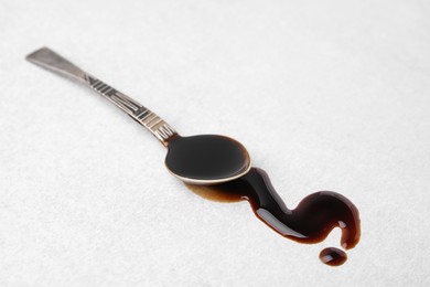 Photo of Spoon with balsamic vinegar on white table