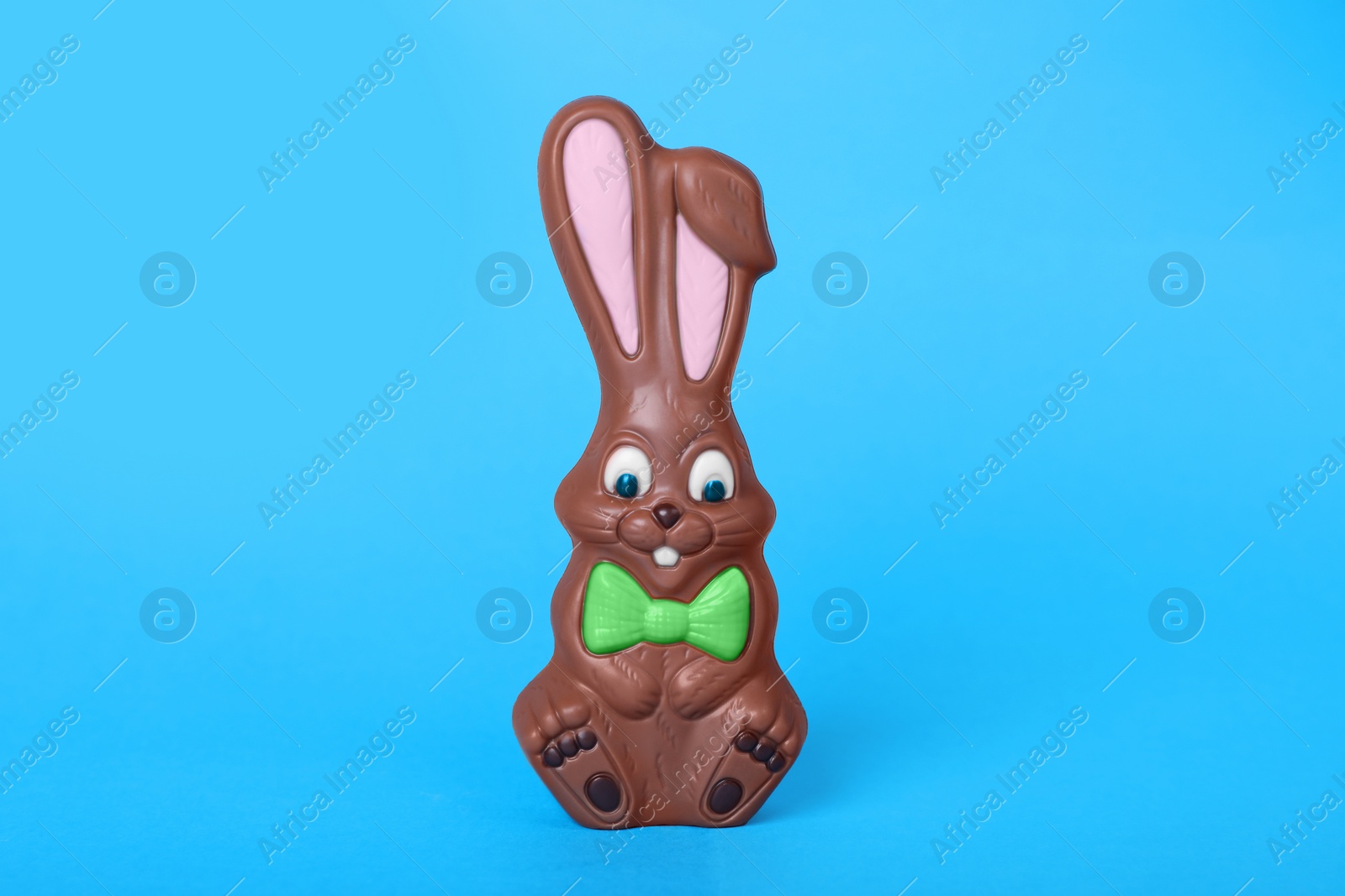 Photo of Chocolate bunny on light blue background. Easter celebration