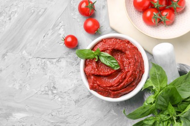 Tasty tomato paste and ingredients on light gray textured table, flat lay. Space for text