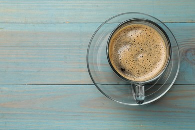 Photo of Cup of aromatic coffee on light blue wooden table, top view. Space for text