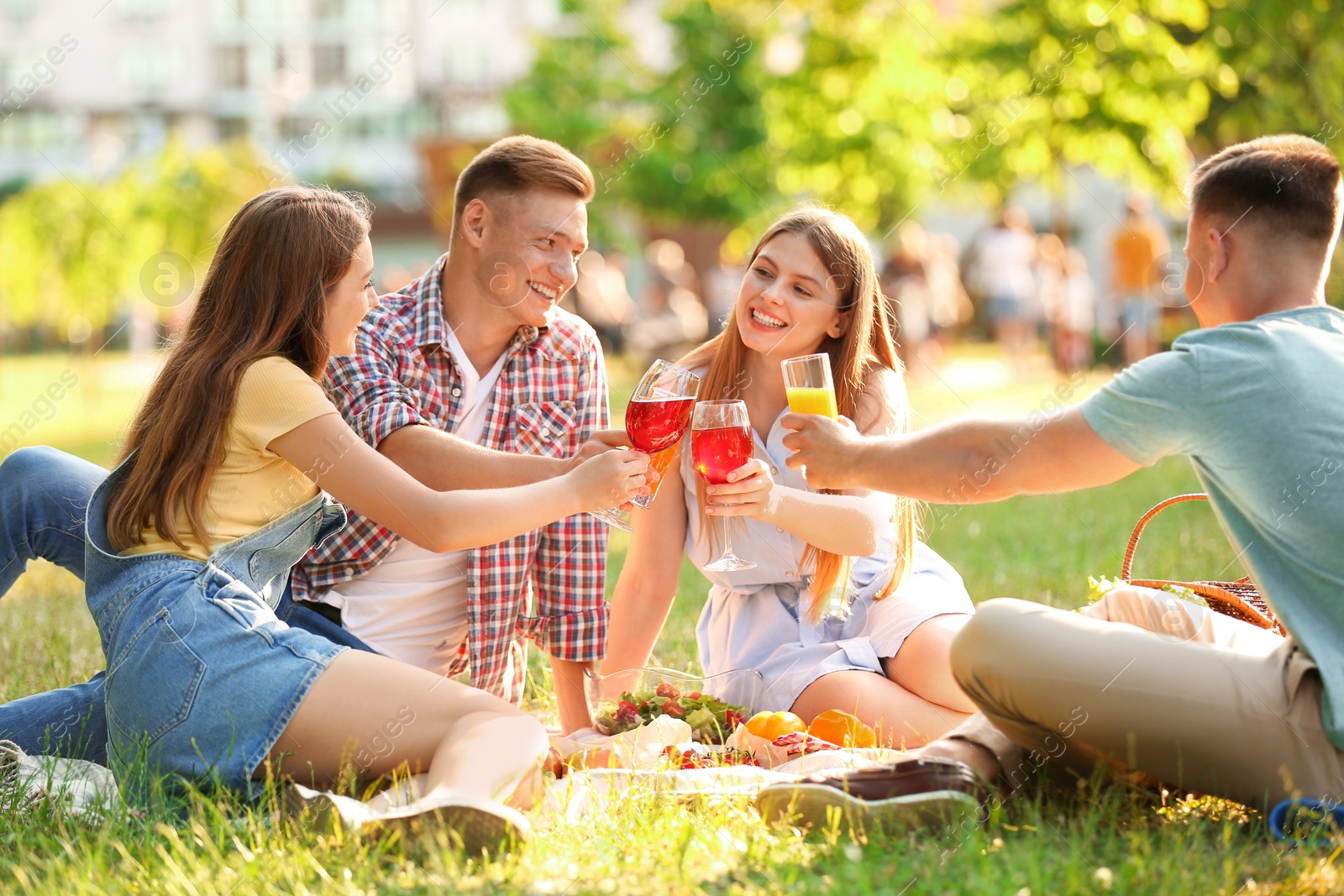 Photo of Young people enjoying picnic in park on summer day