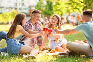 Photo of Young people enjoying picnic in park on summer day