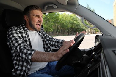 Photo of Emotional man in car. Aggressive driving behavior