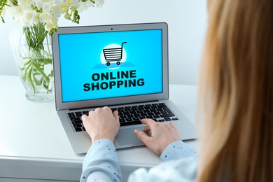 Image of Woman using laptop for online shopping at white table, closeup