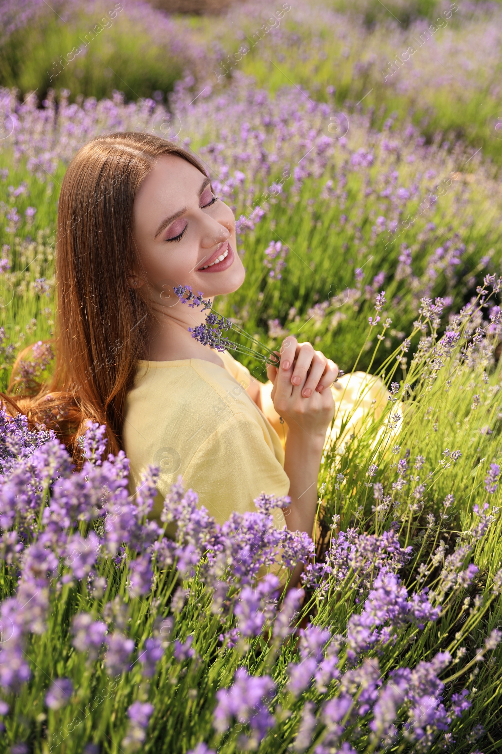 Photo of Young woman in lavender field on summer day